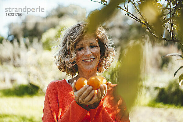Glückliche Frau mit frischen Orangenfrüchten