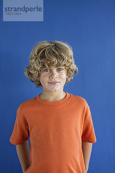 Boy with blond hair against blue background