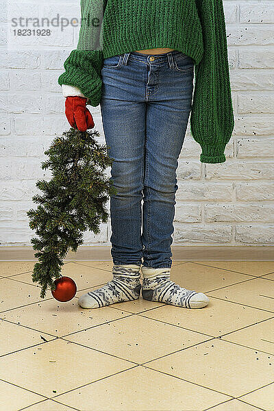 Mädchen steht mit Weihnachtsbaum