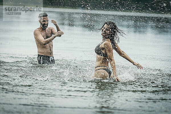 Glücklicher reifer Mann und Frau  die gemeinsam Spaß im See haben