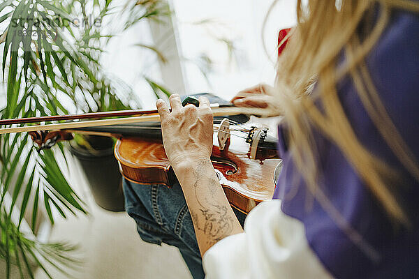 Hände des Geigers  der Geige im Studio hält