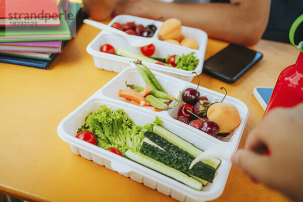 Frisches Obst und Gemüse in der Lunchbox auf dem Tisch