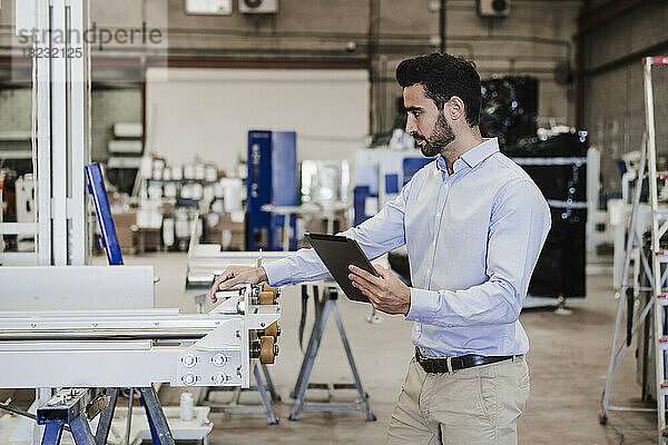 Geschäftsmann mit Tablet-PC-Bediengerät in der Industrie