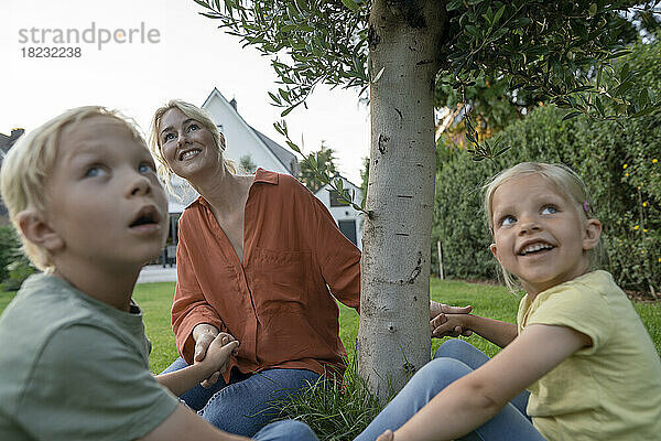 Lächelnde Mutter hält Kinderhände im Hinterhof