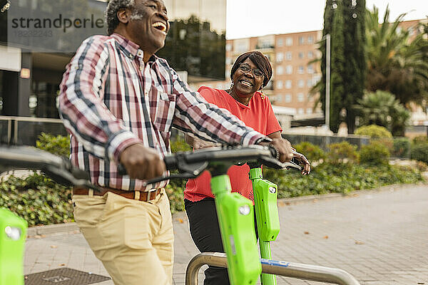 Glückliches Seniorenpaar verbringt seine Freizeit mit Tretrollern