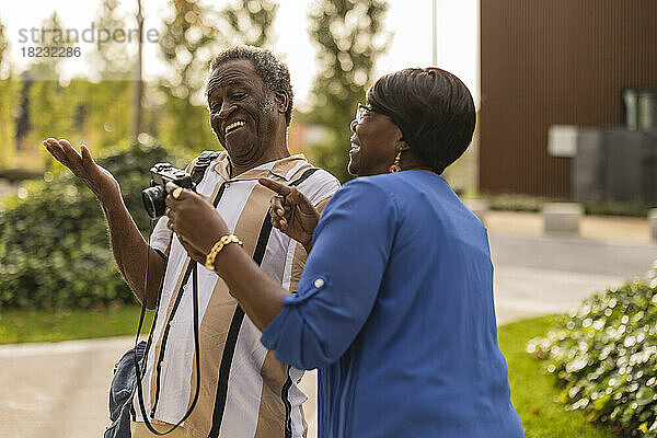Glückliches älteres Paar gestikuliert mit der Kamera im Park