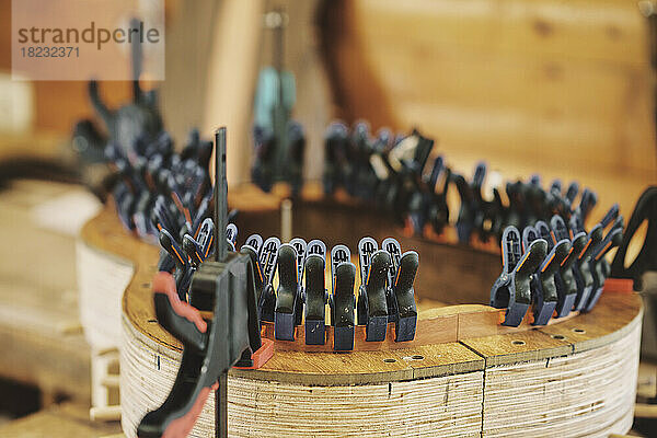 Krämpfe formen Holz für Gitarre auf der Werkbank in der Werkstatt