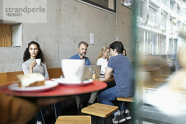 Männer und Frauen sitzen und trinken Kaffee im Café