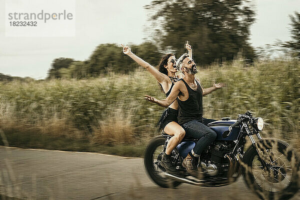 Reifer Mann und Frau fahren Motorrad auf der Straße