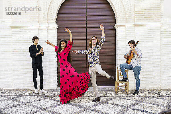 Flamenco-Tänzer treten mit Gitarrist vor der Tür auf