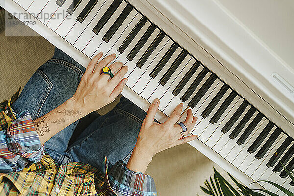 Hands of pianist practicing on piano in studio