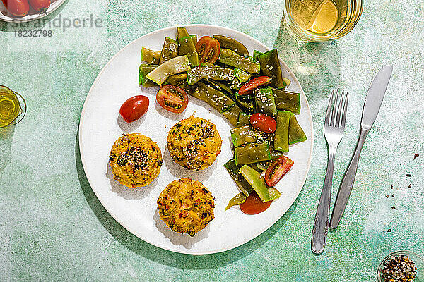 Teller mit Reismuffins mit Salat aus Kirschtomaten und grünen Bohnen