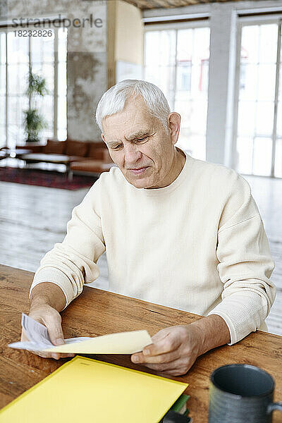 Älterer Mann prüft zu Hause Finanzrechnungen