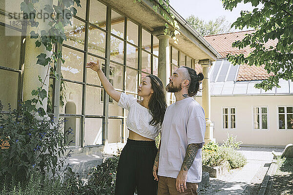 Hipster-Paar untersucht Pflanzen vor dem Haus
