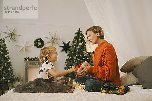 Mutter gibt Tochter zu Hause Weihnachtsgeschenk