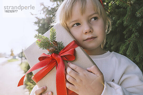 Durchdachtes Mädchen  das Weihnachtsgeschenkbox hält