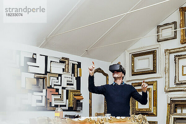 Reifer Mann nutzt Virtual-Reality-Simulator und gestikuliert in der Werkstatt