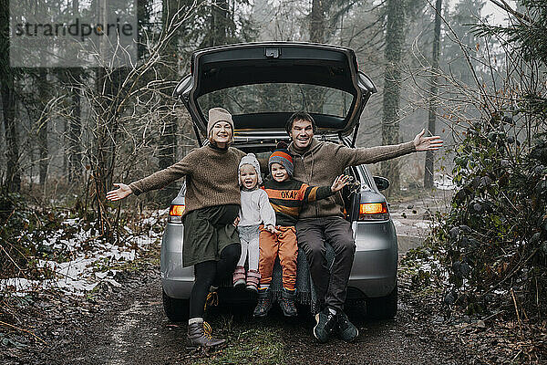 Glückliche Familie verbringt Zeit zusammen im Kofferraum eines Autos
