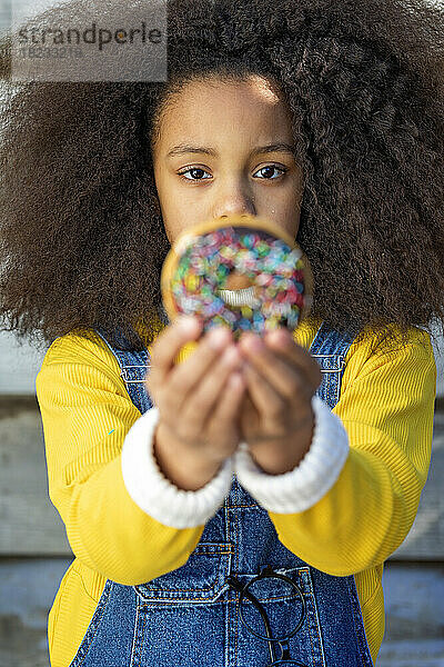 Afro-Mädchen hält frischen Donut