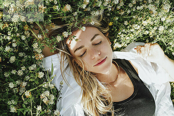 Woman relaxing on meadow of clover flowers