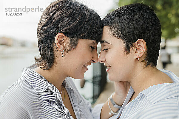 Lesbisches Paar kuschelt sich mit geschlossenen Augen