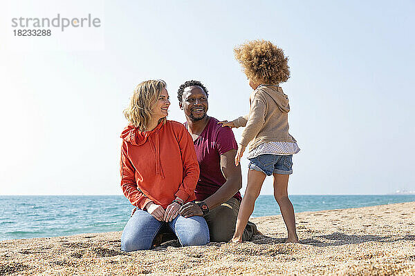 Glückliche Eltern genießen mit ihrer Tochter den Strand