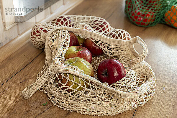 Apples in a mesh bag on kitchen counter