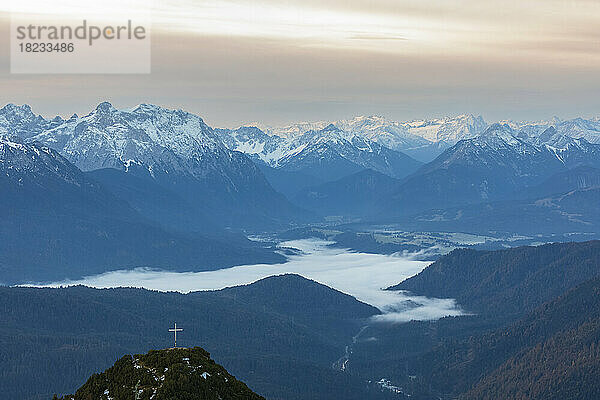 Germany  Bavaria  Foggy valley in Bavarian Prealps with summit cross in foreground