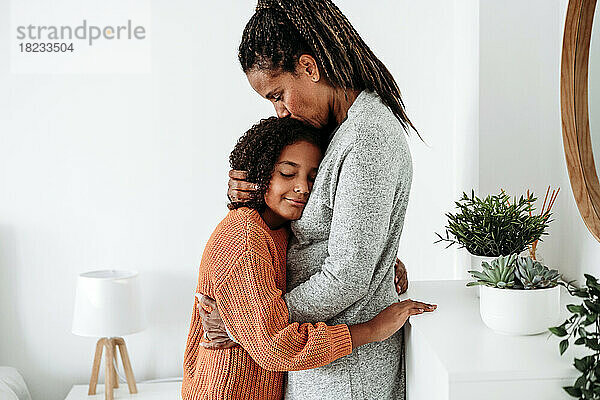 Reife Frau umarmt Tochter zu Hause