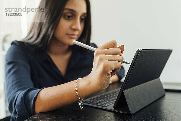 Frau benutzt Tablet-PC auf dem heimischen Tisch