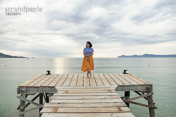 Thoughtful woman standing on jetty