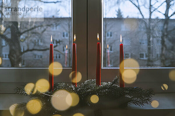 Brennende rote Kerzen auf dem heimischen Tisch im Advent