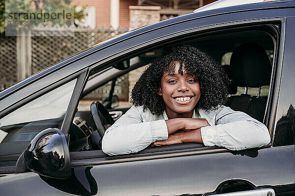 Lächelnde Frau lehnt am Autofenster