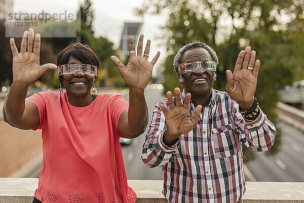 Älteres Paar zeigt Handflächen und trägt eine intelligente Brille