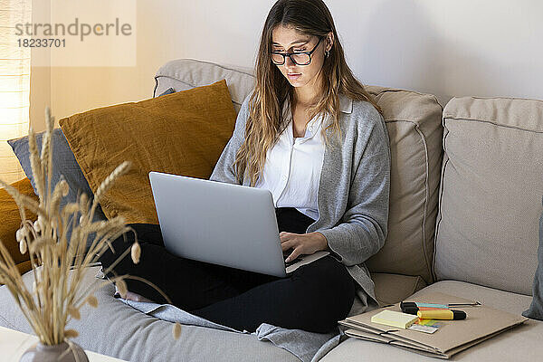 Junge Frau lernt zu Hause am Laptop