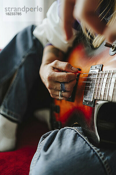 Hand eines Gitarristen  der im Studio E-Gitarre spielt