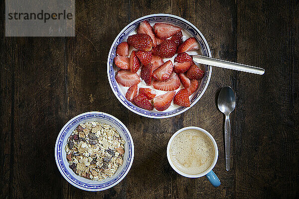 Tray with mug of coffee  muesli and yogurt with strawberries
