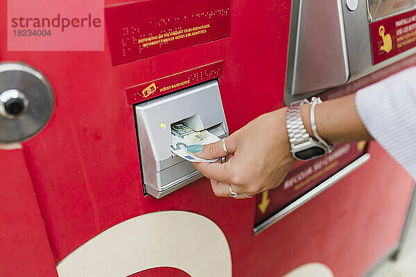Frau entnimmt Geld aus Geldautomaten