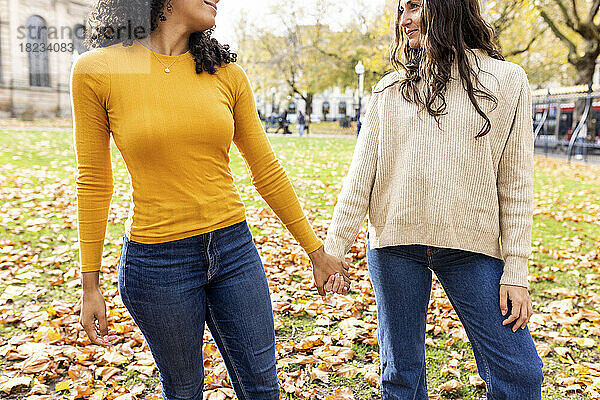 Frau hält Hand eines Freundes im Herbstpark