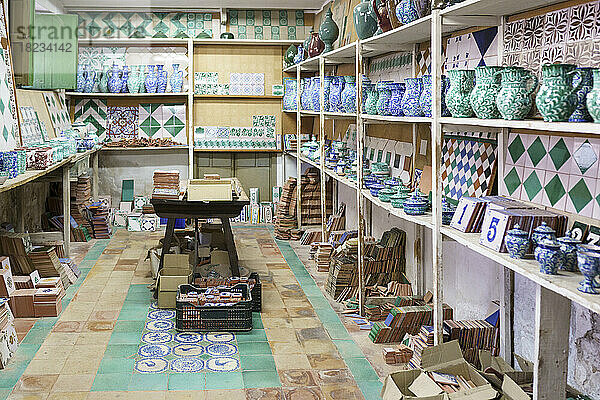 Verschiedene Keramikstücke auf einem Regal in der Werkstatt angeordnet