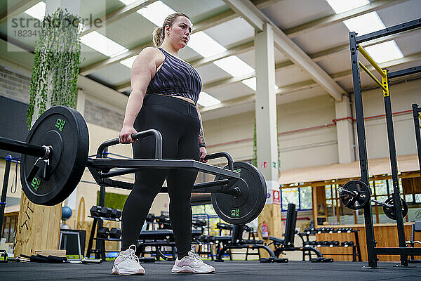 Engagierte junge Frau beim Krafttraining im Fitnessstudio