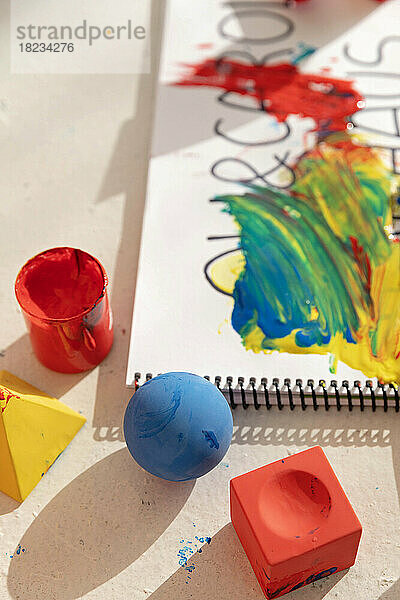 Bunte Spielzeugblöcke und Notizblock mit Farbe bedeckt