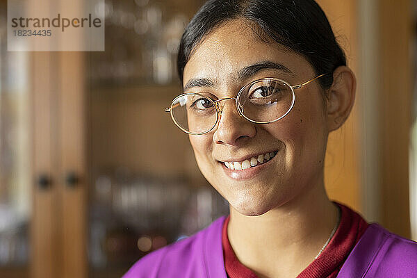 Glücklicher Mitarbeiter im Gesundheitswesen  der zu Hause eine Brille trägt
