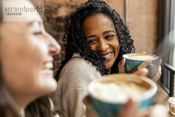 Glückliche Freunde  die im Café Kaffee trinken