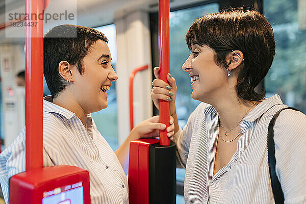 Glückliches lesbisches Paar  das im Bus miteinander redet