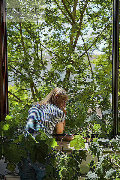 Mature woman standing near window at home