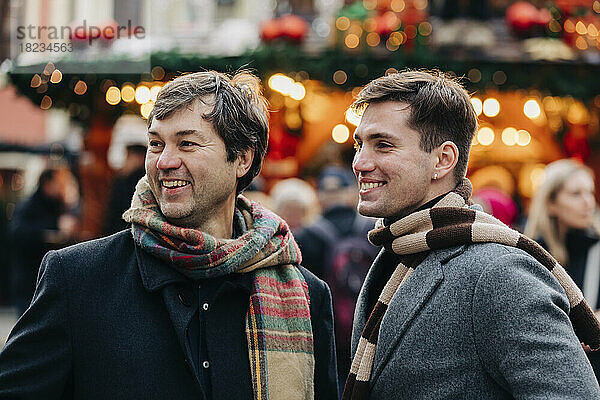 Glücklicher reifer Mann mit Sohn auf dem Weihnachtsmarkt