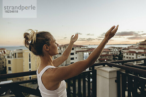 Ruhige Frau genießt den Sonnenuntergang auf der Dachterrasse
