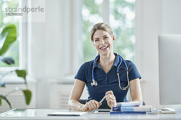Female doctor laughing at desk in medical practice