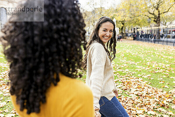 Happy woman with friend at autumn park